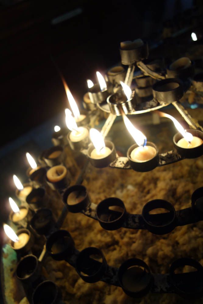 candles lit with candlewax below  in san lorenzo basilica binondo